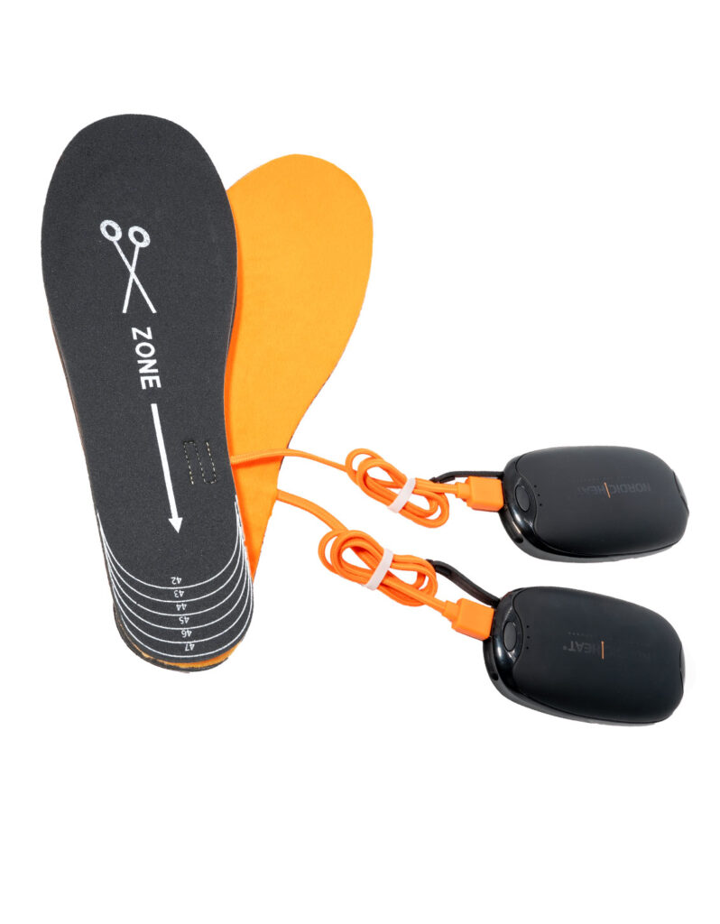 NordicHeat heating insoles in black and orange with connected batteries and cables. Size settings indicated in clear markings on the insoles.