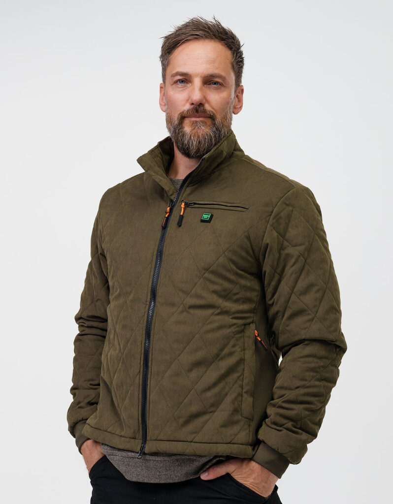 A man wearing an olive green NordicHeat jacket with zipper and chest pocket stands against a gray background.