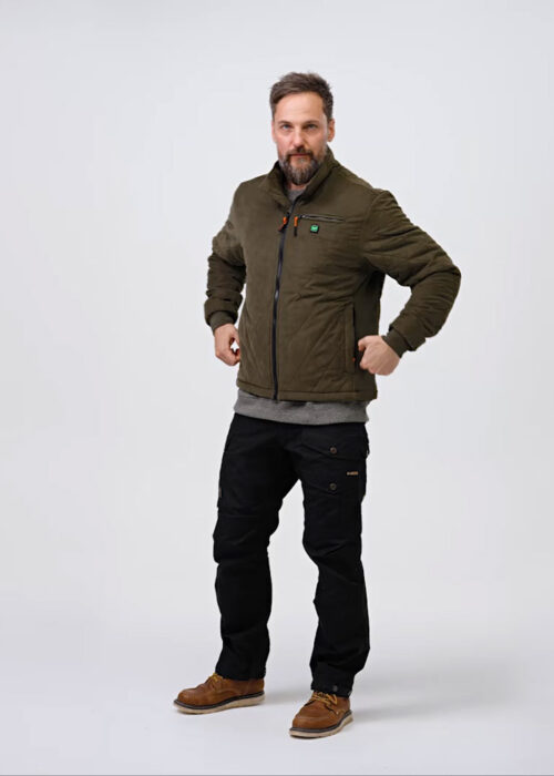 A person is wearing an olive green jacket with visible pockets, black pants and brown shoes on a neutral background. The jacket is the central element.