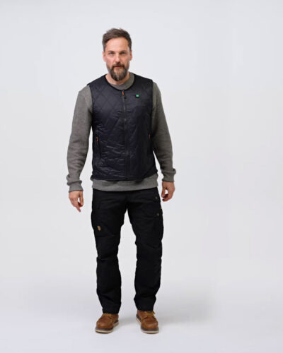 A man wearing a black quilted vest stands in front of a neutral background. The design of the vest indicates that it is from the NordicHeat warmwear collection.