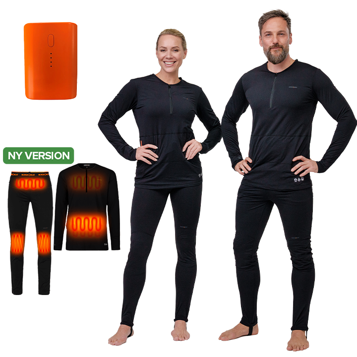 Two people wearing black NordicHeat heating garments stand upright. Inserted graphics show heating zones in the garment and an orange portable heater and the text "NEW VERSION".