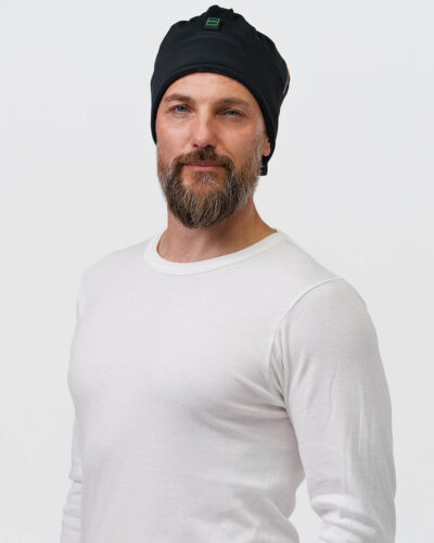 One person wears a black beanie with the NordicHeats logo, wearing a white sweater, promoting comfort and warmth, ideal for an active lifestyle.