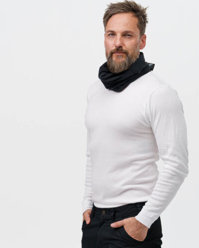 A person wearing a white sweater and a black neck warmer from NordicHeat suggests warmth and comfort. The design supports an active lifestyle in a cool environment. No text is visible.