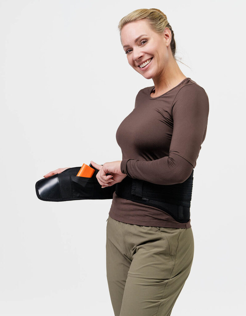Woman adjusts a NordicHeat battery heated garment in a modern design; suitable for active lifestyle and comfort in cold weather. No text visible.
