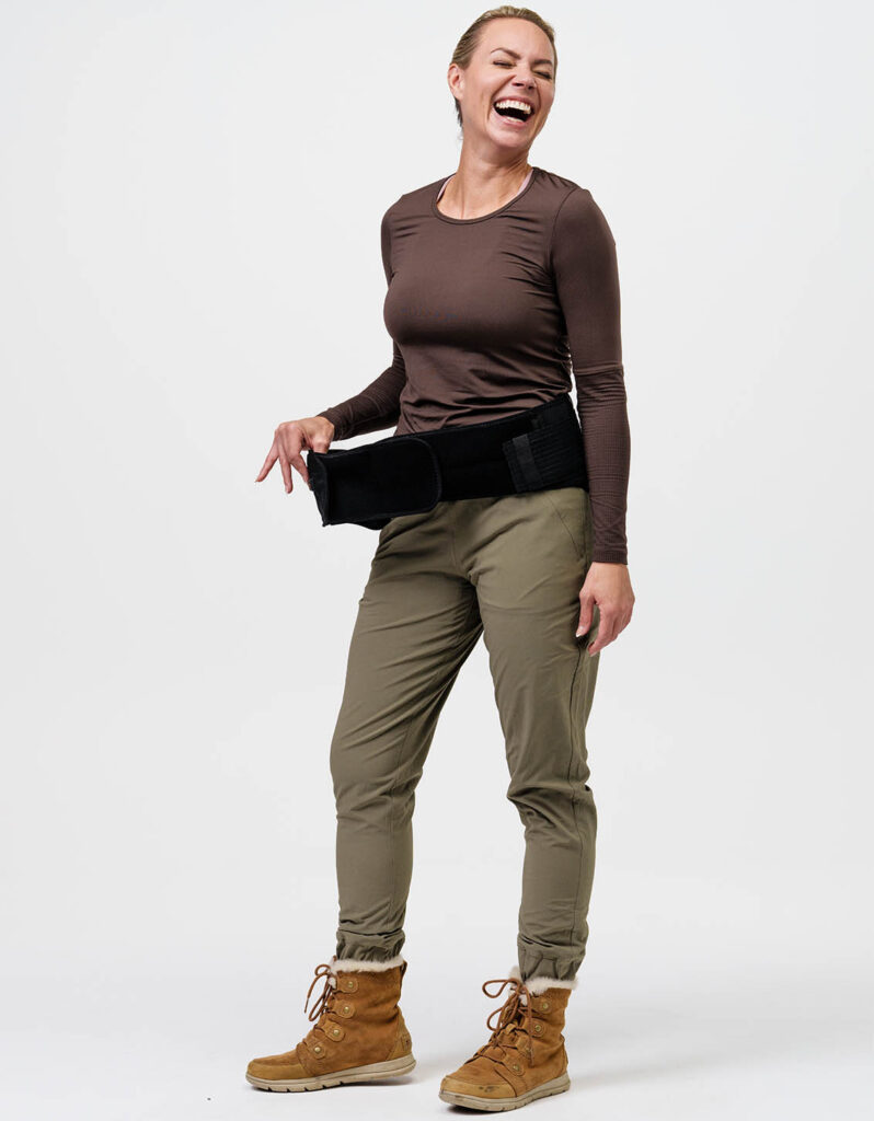 A person wearing a NordicHeat warming belt wearing active winter clothing supports an active lifestyle. The clothing style promotes comfort and mobility in chilly outdoor conditions. No visible text is present.